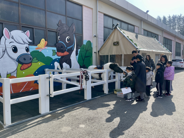 대덕승마장을 찾은 가족단위 방문객들이 말 먹이 주기 체험을 하고 있다.