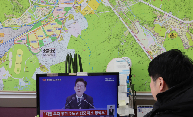 21일 서울 서초구 한 부동산 중개업소에서 관계자가 이재명 대통령 신년 기자회견 방송을 지켜보고 있다. 연합뉴스