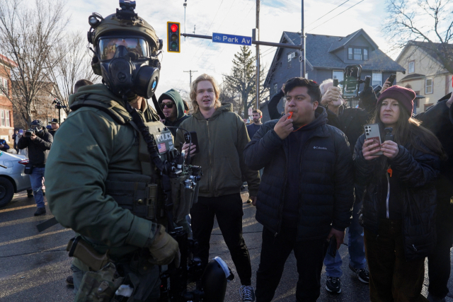 13일(현지시간) 미국 미네소타주 미니애폴리스시에서 주민들이 연방 이민세관단속국 요원의 단속에 항의하는 표시로 호루라기를 불고 있다. 로이터 연합뉴스