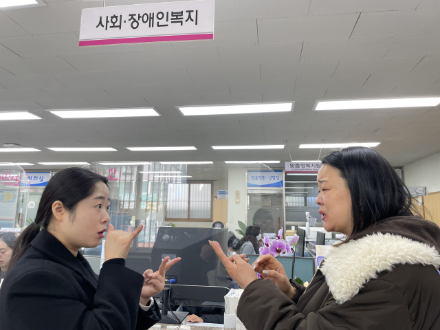 지난 22일 황윤희(28) 수어통역사(왼쪽)가 상인1동 행정복지센터에서 청각장애인 정재연(51) 씨의 민원 업무를 수어로 통역하고 있다. 임소현 기자