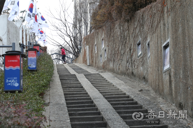 태극기가 걸린 청라언덕 90계단. 대구 3·1운동 당시 학생들이 일본군의 감시를 피해 오르내리며 만세운동을 준비하던 길이다. 계단 벽면에는 당시 학생들의 결의가 기록처럼 남아 있다. 정운철 기자 woon@imaeil.com