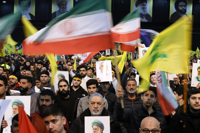 26일(현지시간) 레바논 베이르투 외곽에서 열린 친이란 세력 헤즈볼라 집회에서 집회 참가자들이 이란 최고지도자 알리 하메네이의 초상화와 이란 국기를 들고 이란에 대한 지지 의사를 표시하고 있다. EPA 연합뉴스