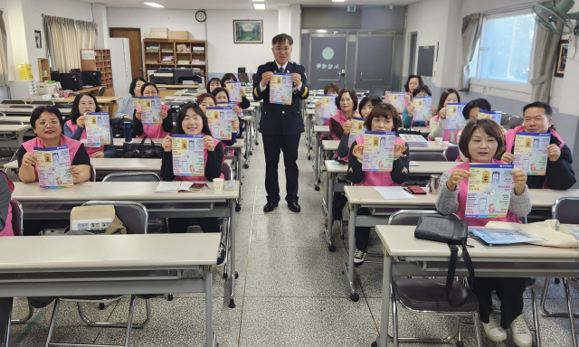 영주경찰서 보이스피싱 범죄 예방 교육에 참여한 경로당 행복선생님들이 교육 자료를 들어 보이고 있다. 영주서 제공
