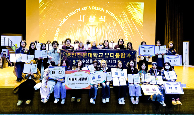 지난 24일 제24회 월드뷰티아트＆디자인 국제공모전 시상식에서 입상한 영진전문대학교 뷰티융합과 학생들이 교수진 및 대회 관계자들과 함께 기념촬영을 하고 있다. 영진전문대 제공