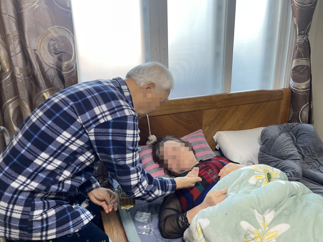 김영섭(71·가명) 씨는 본인도 전립선암을 앓고 있는 환자지만 뇌병변 장애와 위암으로 누워있는 아내 이원자(71·가명) 씨를 정성으로 돌본다. 김봄이 기자