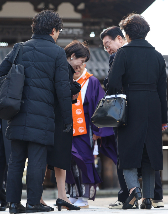 이재명 대통령과 다카이치 사나에 일본 총리가 지난 1월 14일 일본 나라현 대표 문화유적지인 호류지(법륭사)에서 기념촬영을 마친 뒤 이 대통령이 착용한 운동화에 대해 이야기를 하고 있다. 연합뉴스