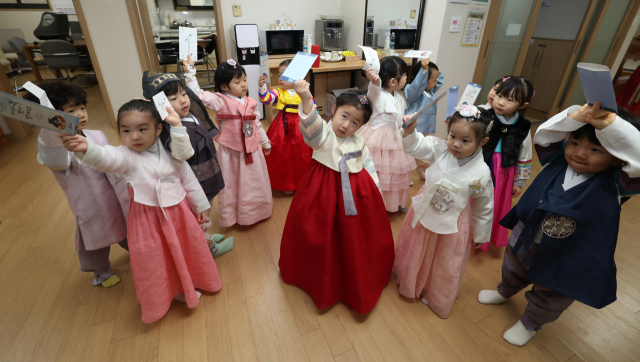 11일 서울 송파구의 한 경로당에서 한복을 입은 어린이집 아이들이 세배를 하고 세뱃돈이 든 봉투를 들어보이고 있다. 연합뉴스