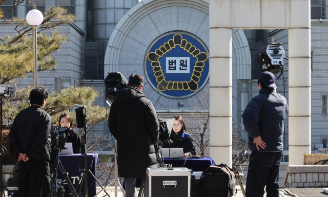 12·3 비상계엄과 관련한 윤석열 전 대통령의 내란 우두머리 혐의 사건 1심 선고를 앞둔 18일 서울 서초구 서울중앙지법에서 방송사 관계자들이 보도를 하고 있다. 연합뉴스