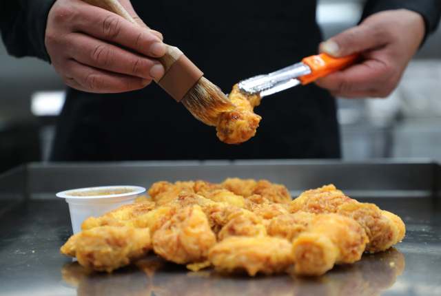 교촌치킨은 튀김옷의 바삭함을 살리고 프리미엄 소스의 풍미를 극대화하기 위해, 조각마다 얇고 고르게 소스를 입히는 독자적인 조리 방식을 고수하고 있다. 교촌에프앤비 제공