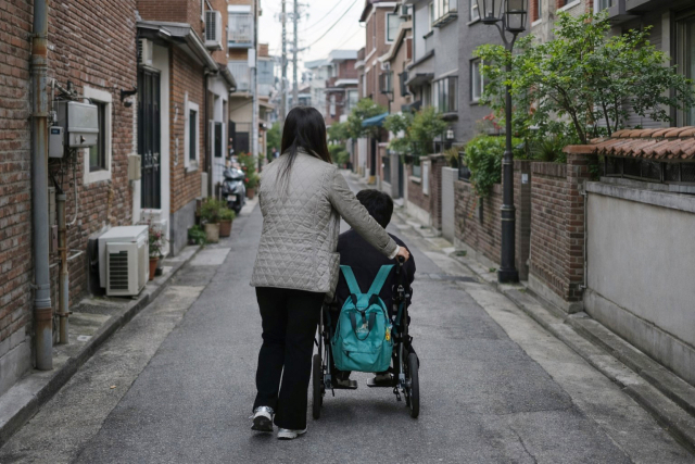 뇌병변 중증과 지적장애를 동반한 중복장애를 앓고 있는 이규현 군이 어머니 장의주 씨의 도움을 받으며 등교하고 있다. 정운철 기자 woon@imaeil.com