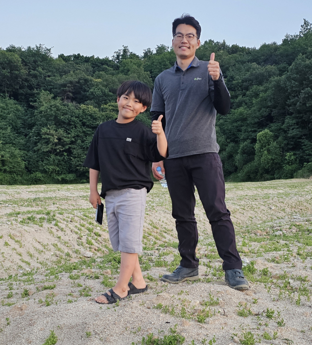 김태준 농부가 도라지밭에서 아들 김산아 군과 함께 엄지를 들어 올리고 있다.