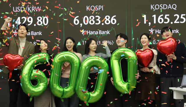 코스피가 사상 처음으로 6,000을 돌파해 거래를 마친 26일 서울 중구 하나은행 딜링룸에서 딜러들이 기념 세리머니를 하고 있다. 연합뉴스