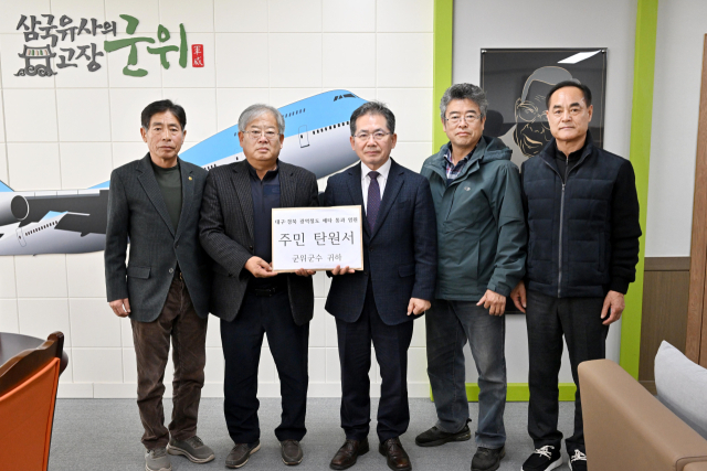 대구 군위군 주민 대표 4명은 26일 주민 4천여명의 서명이 담긴 주민 탄원서와 서명부를 김진열 군위군수에게 제출했다. 이들은 대구~경북 광역철도의 조속한 예비타당성조사 통과 등을 촉구했다. 군위군 제공.