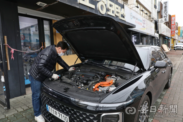 보닛을 연 차량과 부품 상가가 늘어선 남산동 자동차부속 골목. 