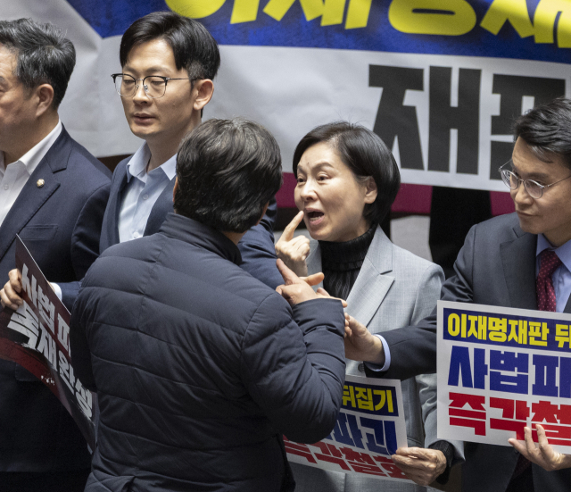 27일 국회에서 열린 2월 임시국회 8차 본회의에서 전날 상정된 헌법재판소법 일부개정법률안(재판소원제)에 대한 무제한 토론(필리버스터) 종결을 위한 투표가 시작되자 국민의힘 의원들이 손팻말과 피켓을 들고 시위를 펼치는 동안 민주당 양문석 의원과 국민의힘 서명옥 의원(가운데)이 설전을 벌이고 있다. 두 의원의 설전은 국민의힘 시위를 휴대폰으로 찍던 조국혁신당 이해민 의원을 국민의힘 서명옥 의원이 손팻말로 제지하면서 시작됐다. 이를 뒤에서 지켜보던 민주당 양문석 의원이 서 의원에게 강하게 항의하면서 여야 의원들의 말싸움이 시작됐다. 연합뉴스