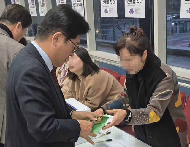 김종혁 전 국민의힘 최고위원이 지난 26일 함운경·장진영·이종철 당협위원장·백남환 마포구의회 의장 공동출판기념회를 찾아 5만 원 여러장을 봉투에 담아 행사 관계자에게 전달하고 있다. 정현환 기자