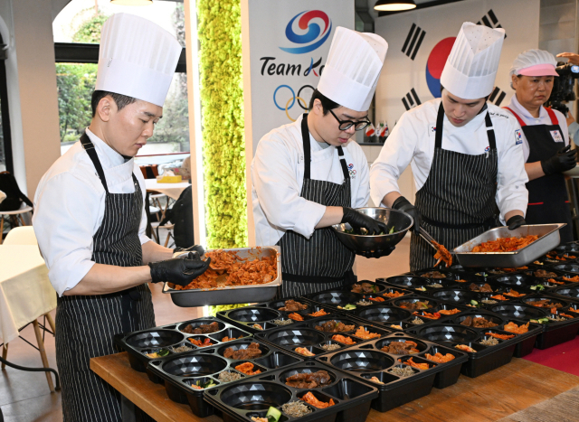 2월 9일(현지시간) 이탈리아 밀라노에서 열린 대한체육회가 운영하는 급식지원센터 공개 미디어행사에서 김중현 조리장과 영양사들이 온기코퍼레이션의 발열 도시락 용기를 이용해 국가대표팀 선수들에게 전달한 도시락을 만들고 있다. 대한체육회 제공