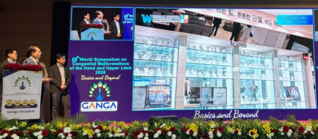 2032년 세계 심포지엄을 유치하기 위해 W병원의 홍보 영상이 상영되고 있다.