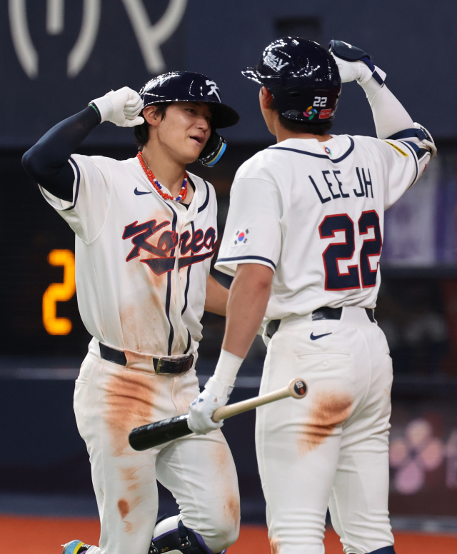 한국의 김도영이 2일 일본 오사카 교세라돔에서 열린 월드베이스볼클래식(WBC) 평가전 일본프로야구 한신 타이거스와의 경기 5회초 솔로홈런을 친 뒤 홈을 밟으며 이정후와 기쁨을 나누고 있다. 연합뉴스