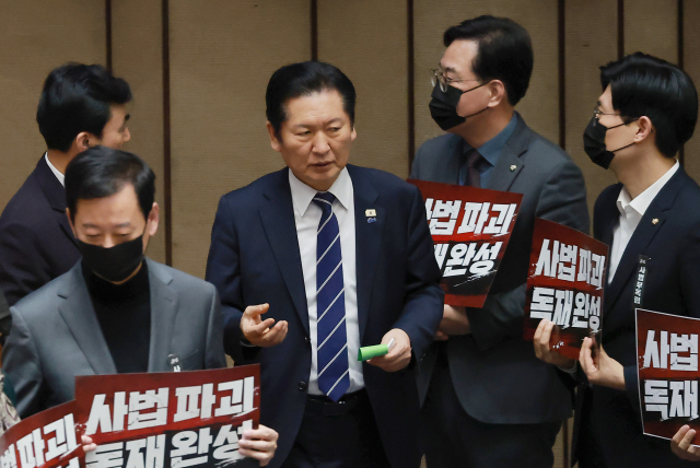 더불어민주당 정청래 대표가 지난 28일 국회에서 열린 2월 임시국회 8차 본회의에서 전날 상정된 법원조직법 개정안(대법관 증원법)에 대한 무제한 토론 종결 동의의 건 투표를 하고 있다. 정 대표 주위에서 국민의힘 송언석 원내대표 등 의원들이 사법개혁 3법(법왜곡죄·재판소원제·대법관 증원) 규탄 시위를 하고 있다. 연합뉴스