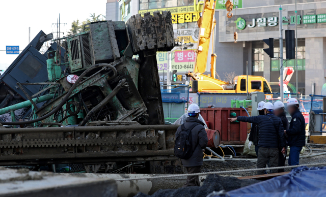 4일 오전 대구 수성구 만촌네거리에서 만촌역 지하통로 공사를 하던 천공기가 쓰러진 가운데 공사업체 관계자들이 현장을 확인하고 있다. 김영진 기자 kyjmaeil@imaeil.com