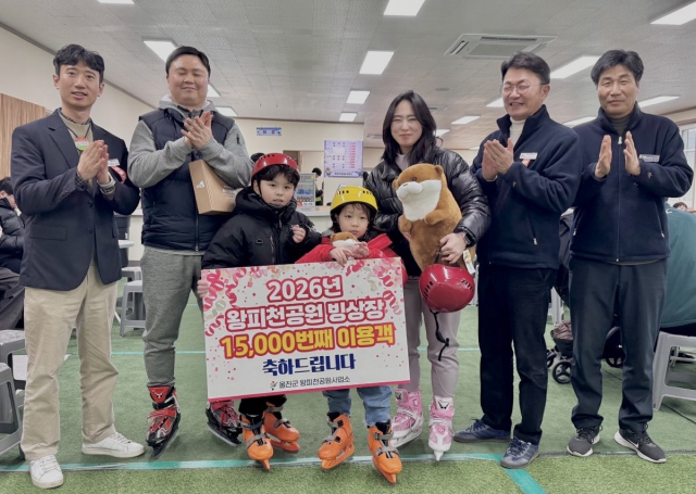 왕피천공원빙상장 1만5천번째 입장한 경기도에서 온 가족이 기념사진을 찍고 있다. 울진군 제공