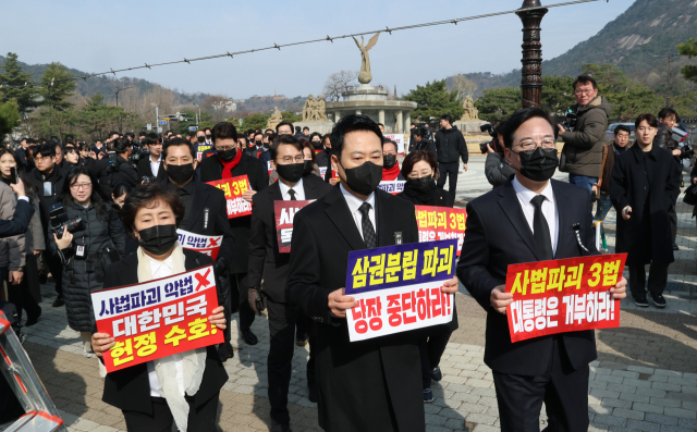 장동혁 대표와 송언석 원내대표를 비롯한 국민의힘 의원들이 5일 청와대 사랑채 앞에서 의원총회를 마친 뒤 손팻말을 들고 청와대 방향으로 이동하고 있다. 연합뉴스