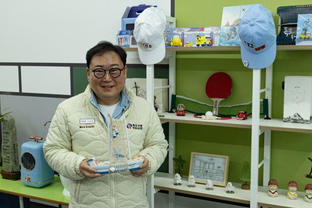 이승원 대구시요트협회장이 요트 모형과 탁구 라켓, 독도 관련 홍보물을 놓은 장식대를 소개하고 있다. 이화섭 기자