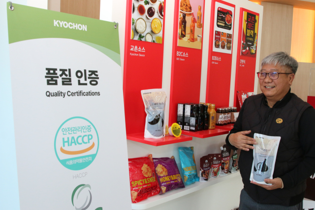 김태윤 비에이치앤바이오 대표가 충북 진천에 위치한 소스 전문 스마트 팩토리에서 교촌의 핵심 경쟁력인 파우치 형태의 각종 소스 라인업을 소개하고 환하게 웃고 있다. 비에이치앤바이오는 100% 국내산 계약 재배 원료와 결벽에 가까운 위생 관리를 통해 전 세계에 