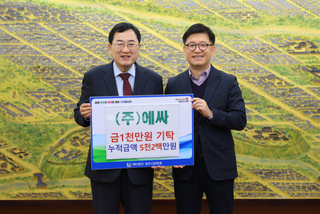 윤영내(오른쪽) ㈜에싸 대표이사가 경주시장학회 이사장인 주낙영 시장에게 장학금 전달식을 갖고 기념촬영을 하고 있다.