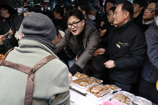 한동훈 전 국민의힘 대표가 7일 부산 북구 구포시장의 한 족발집을 찾아 상인과 인사하고 있다. 연합뉴스