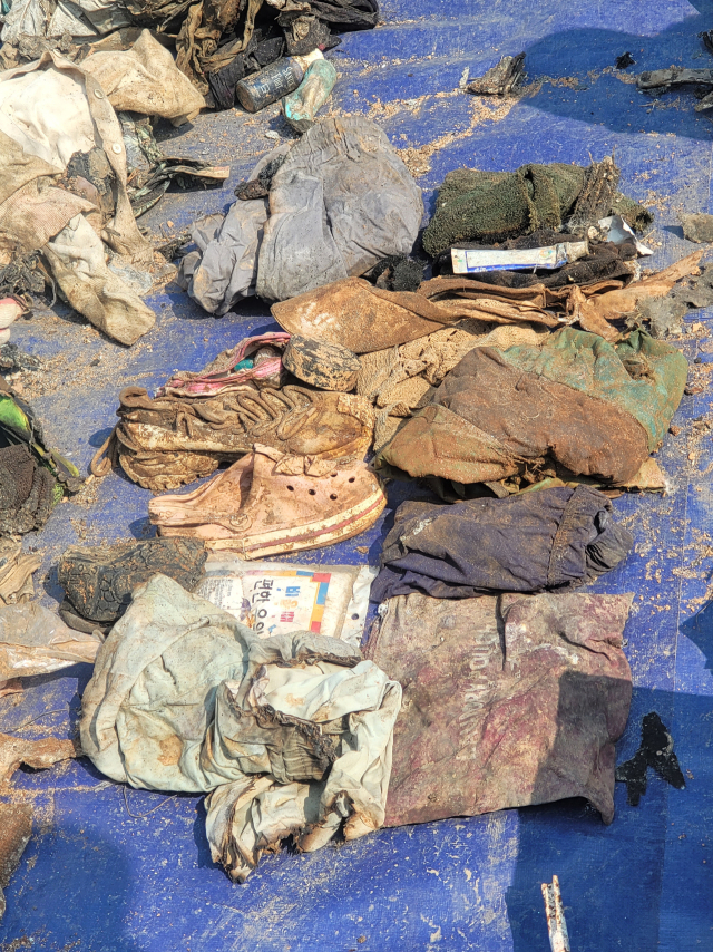 12일 국토교통부와 항공철도사고조사위원회, 전남과학청 과학수사대가 제주항공 참사 여객기 잔해 재조사 현장에서 발견된 유류품이 바닥에 놓여있다. 이날 현장에서는 희생자로 추정되는 유해 24점이 발견됐다. 연합뉴스