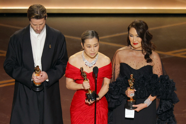 수상 소감 발표하는 매기 강(가운데) 감독. 로이터=연합뉴스