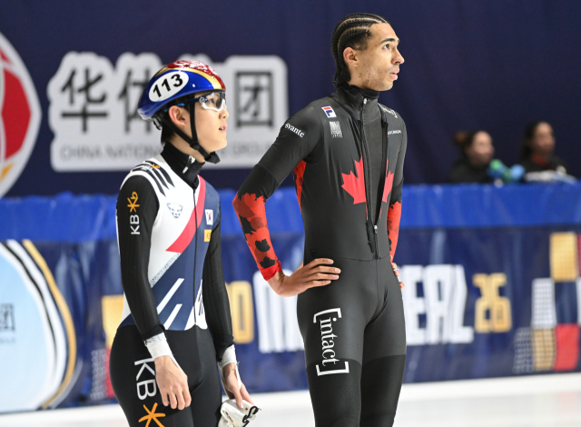 지난 15일 캐나다 몬트리올에서 열린 ISU 세계 쇼트트랙 스피드 스케이팅 선수권 대회 1,000m 결승전 후, 한국의 임종언(왼쪽)과 캐나다의 윌리엄 단지누(오른쪽)가 대형 스크린을 올려다보고 있다. AP연합뉴스