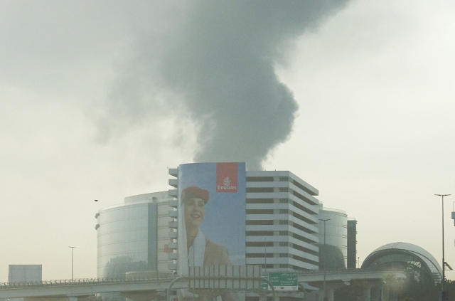 16일(현지시간) 아랍에미리트(UAE) 두바이 공항에서 검은 연기가 피어오르고 있다. 차량 운행 중 촬영된 모습. 로이터 연합뉴스