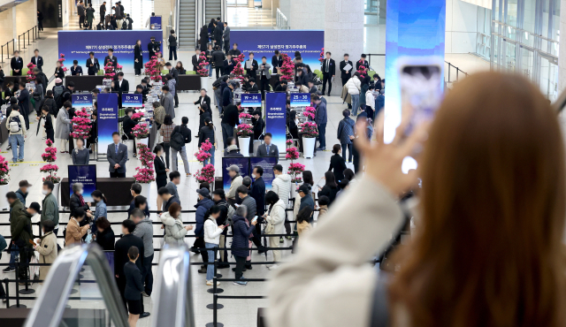 18일 경기도 수원시 영통구 수원컨벤션센터에서 열린 제57기 삼성전자 정기주주총회에서 주주들이 주주 확인을 하고 있다. 연합뉴스