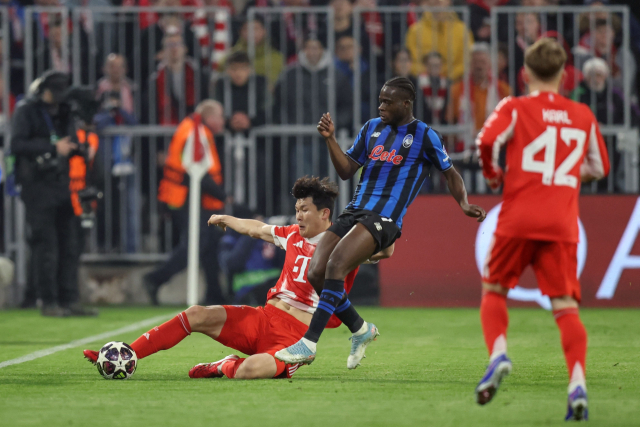 바이에른 뮌헨의 김민재가 19일 독일 뮌헨의 알리안츠 아레나에서 열린 UEFA 챔피언스리그 16강 2차전 도중 아탈란타의 카말딘 술레마나에 앞서 태클로 공을 확보하고 있다. AFP 연합뉴스