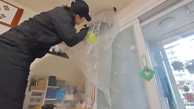 강병수 씨가 어르신 댁에서 에어컨 분해 청소를 하고 있다.
