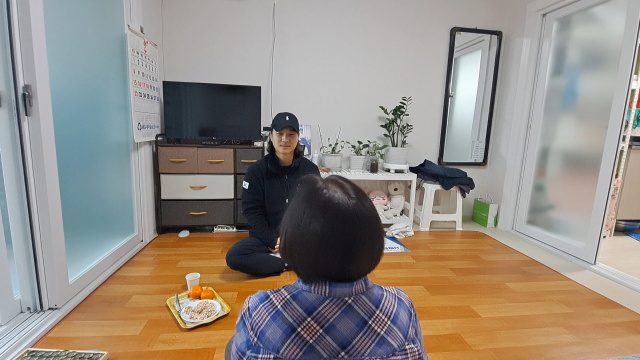 강병수 씨가 에어컨 청소를 위해 방문한 어르신 댁에서 작업 중간 대화를 나누고 있다.