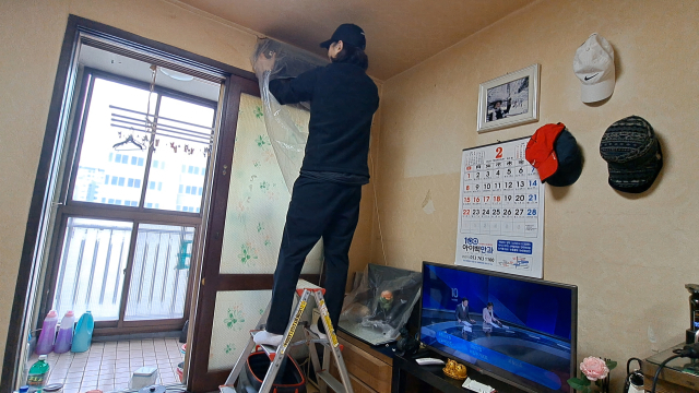 강병수 씨가 어르신 댁에서 에어컨 분해 청소를 하고 있다.