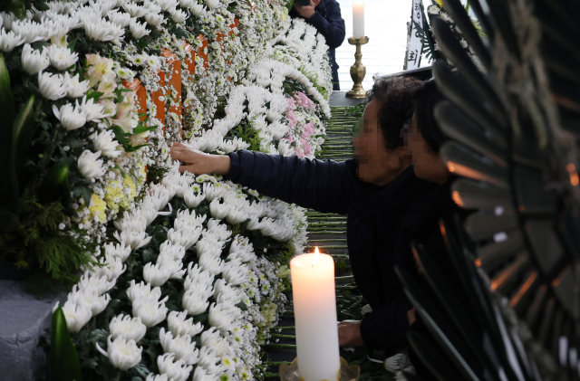 22일 대전시청에 마련된 대전 안전공업 화재 희생자 합동분향소에서 한 유족이 아들 이름을 만지고 있다. 연합뉴스