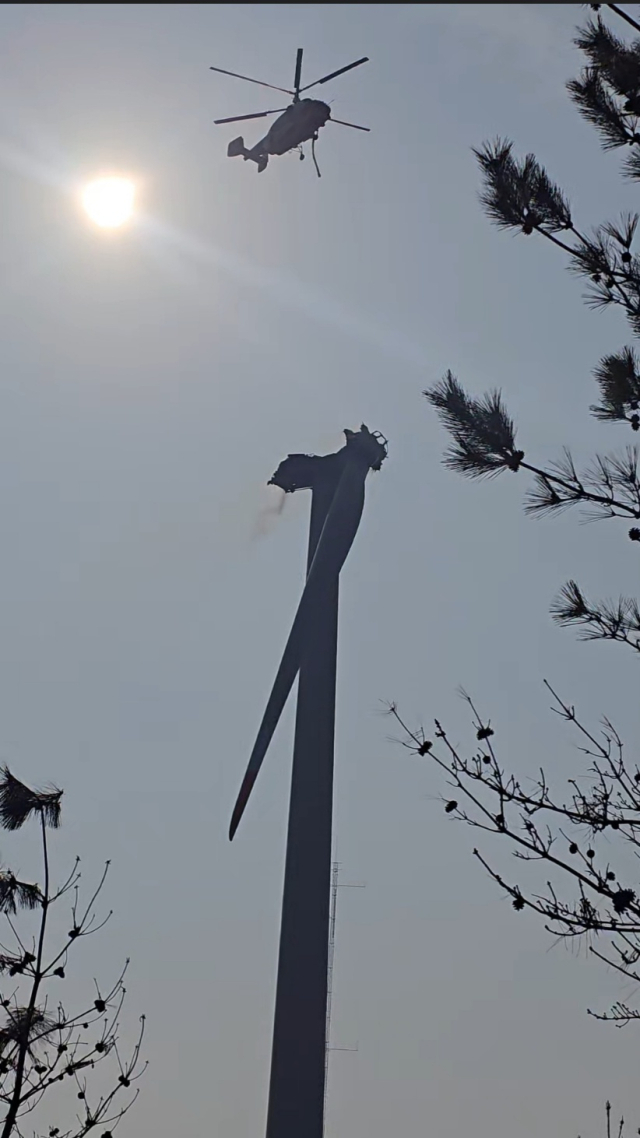 블레이드가 떨어져 나간 풍력발전기 위로 헬기가 화재진압을 하고 있다. 경북소방본부 제공