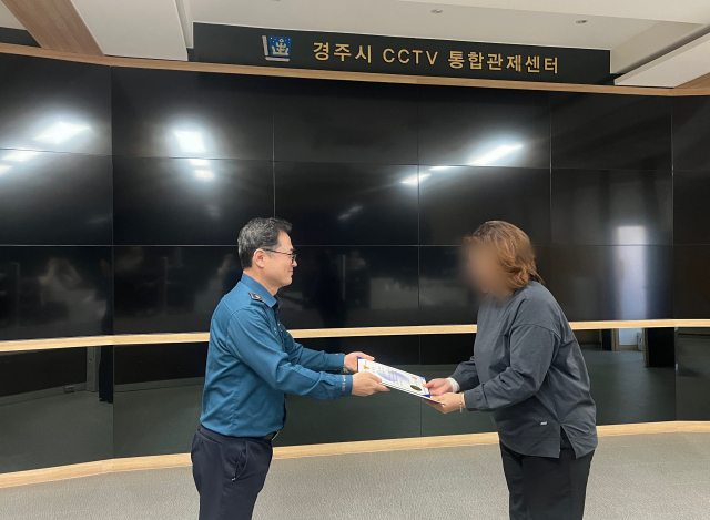 경주시 CCTV통합관제센터 관제요원(오른쪽)이 경주경찰서로부터 가사장을 받고 있다. 경주경찰서 제공