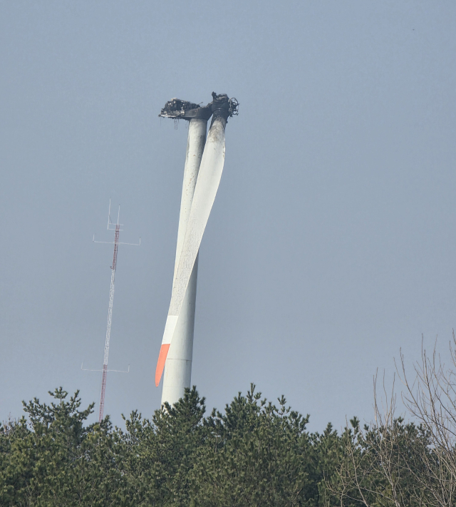23일 화재가 발생한 영덕 풍력발전기 21호기가 24일에도 불길을 머금은 채 위태롭게 서 있다. 박승혁 기자