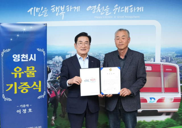 최기문 영천시장과 기증자 이정호씨(오른쪽)가 유물 기증식을 하고 있다. 영천시 제공