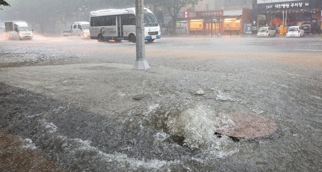 집중호우에 따른 역류로 개방된 맨홀. 연합뉴스