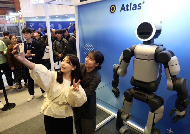 4일 코엑스에서 열린 2026 스마트공장·자동화산업전에서 모델들이 현대글로비스 아틀라스와 기념촬영을 하고 있다. 연합뉴스