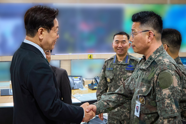 이재명 대통령이 27일 서울 용산 국방부에서 전군주요지휘관회의를 마친 뒤 지휘통제실을 찾아 조성현 대령을 격려하며 악수하고 있다. 12·3 비상계엄 당시 수도방위사령부 제1경비단장이었던 조성현 대령은 국회로 출동하는 병력에 