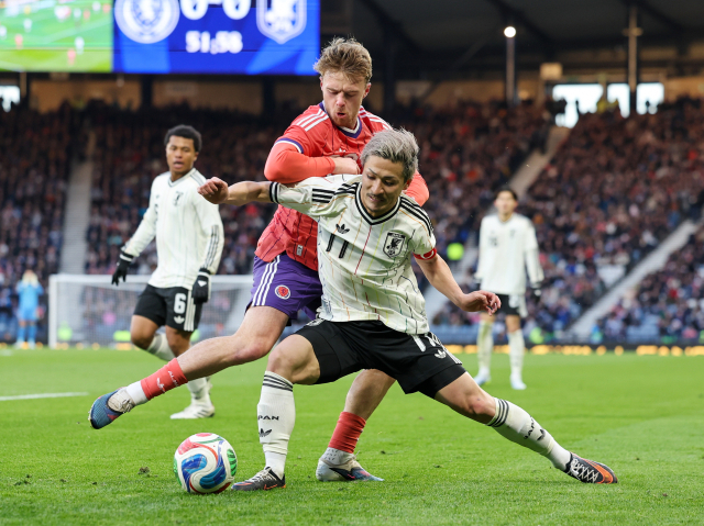 일본의 마에다 다이젠이 29일 영국 스코틀랜드 글래스고에서 열린 월드컵 대비 평가전 도중 스코틀랜드의 토미 콘웨이와 공을 다투고 있다. EPA 연합뉴스