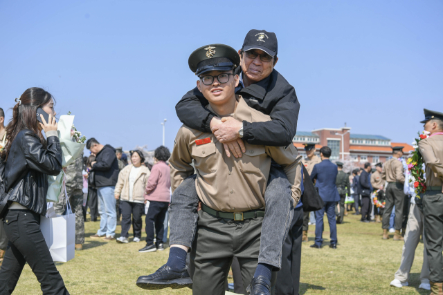 2일 해병대 교육훈련단 연병장에서 해병대 최초 4대 해병 가족이 된 김준영 이병이 2대 해병인 할아버지 김은일 옹을 업고 기념사진을 촬영하고 있다. 해병대 교육훈련단 제공.